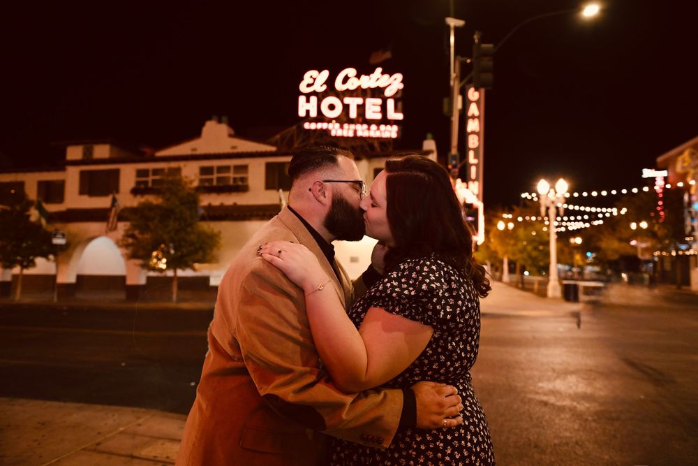 Couple kissing at night in front of the El Cortez Hotel neon sign in downtown Las Vegas.