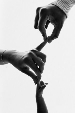 Black and white photo of three hands touching fingertips, symbolizing family connection across generations.