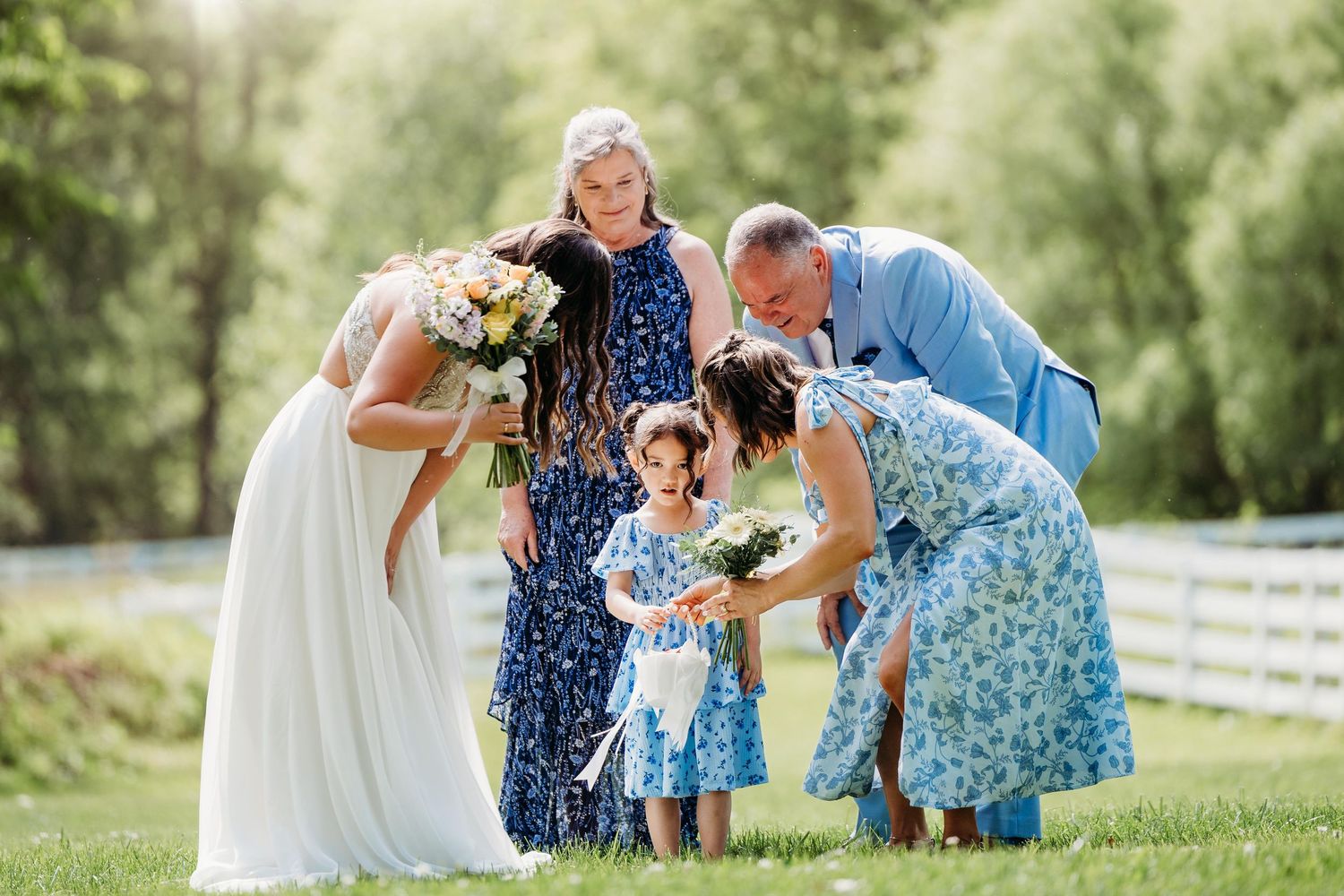 A joyful celebration with bubbles at an outdoor venue as a bride in a flowing white dress descends the steps.