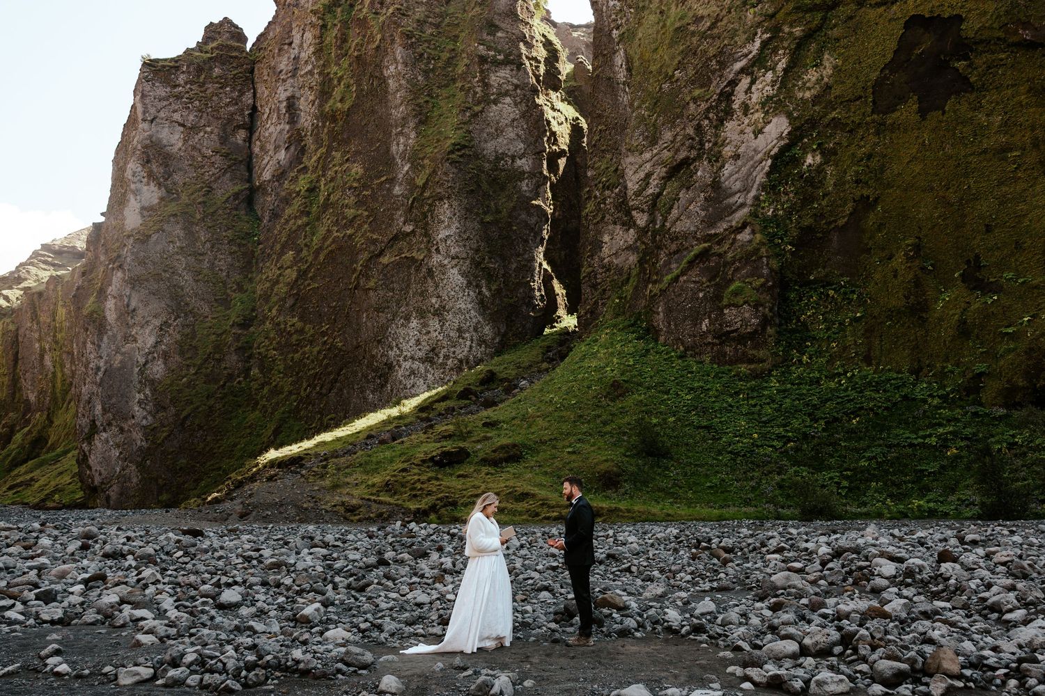 Bride and groom reading vows in a fern and moss filled canyon in Thórsmörk, Iceland