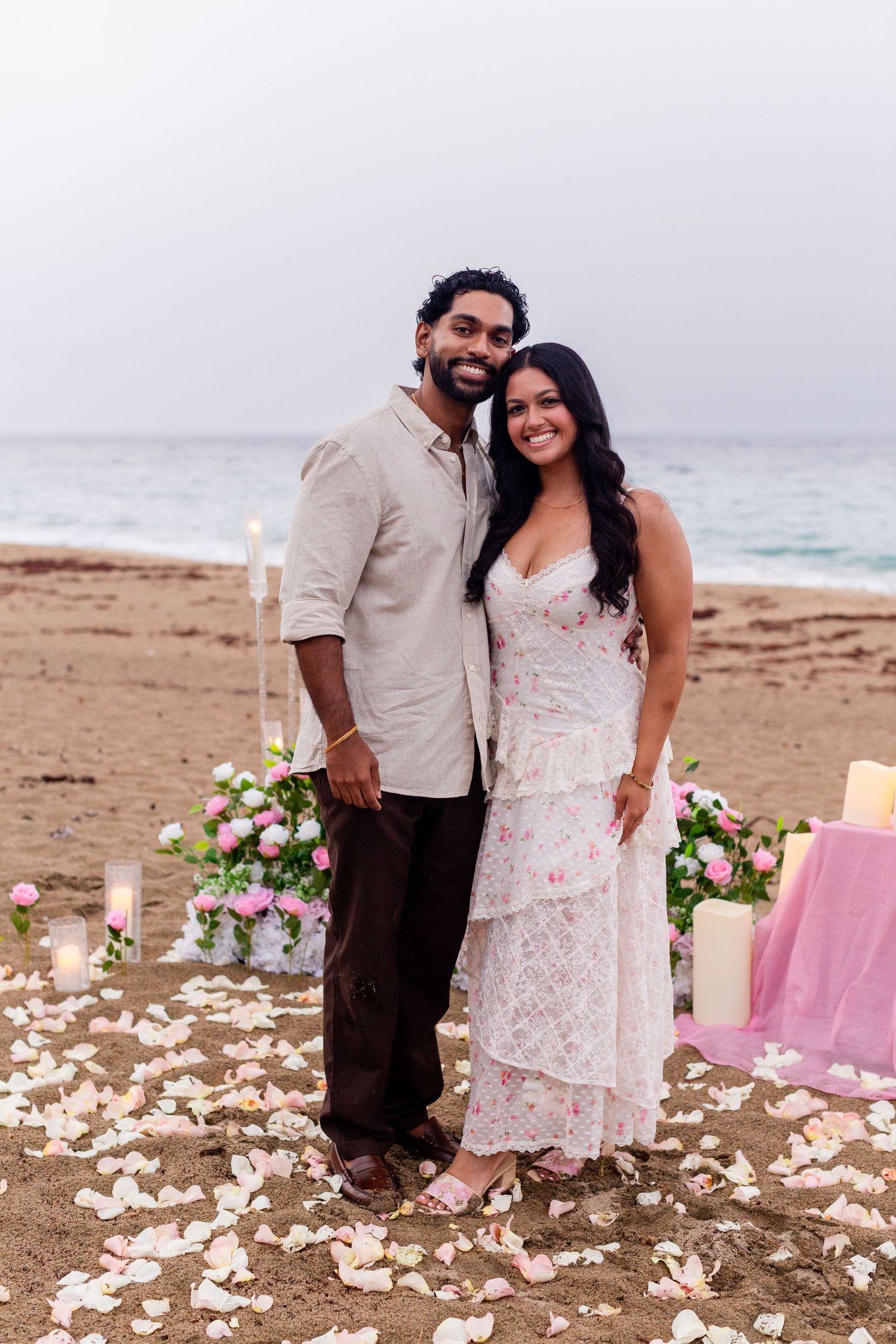 Engagement portrait on the beach. Man and woman with flowers and candles. Playa Guajataca, Isabela, Puerto Rico.