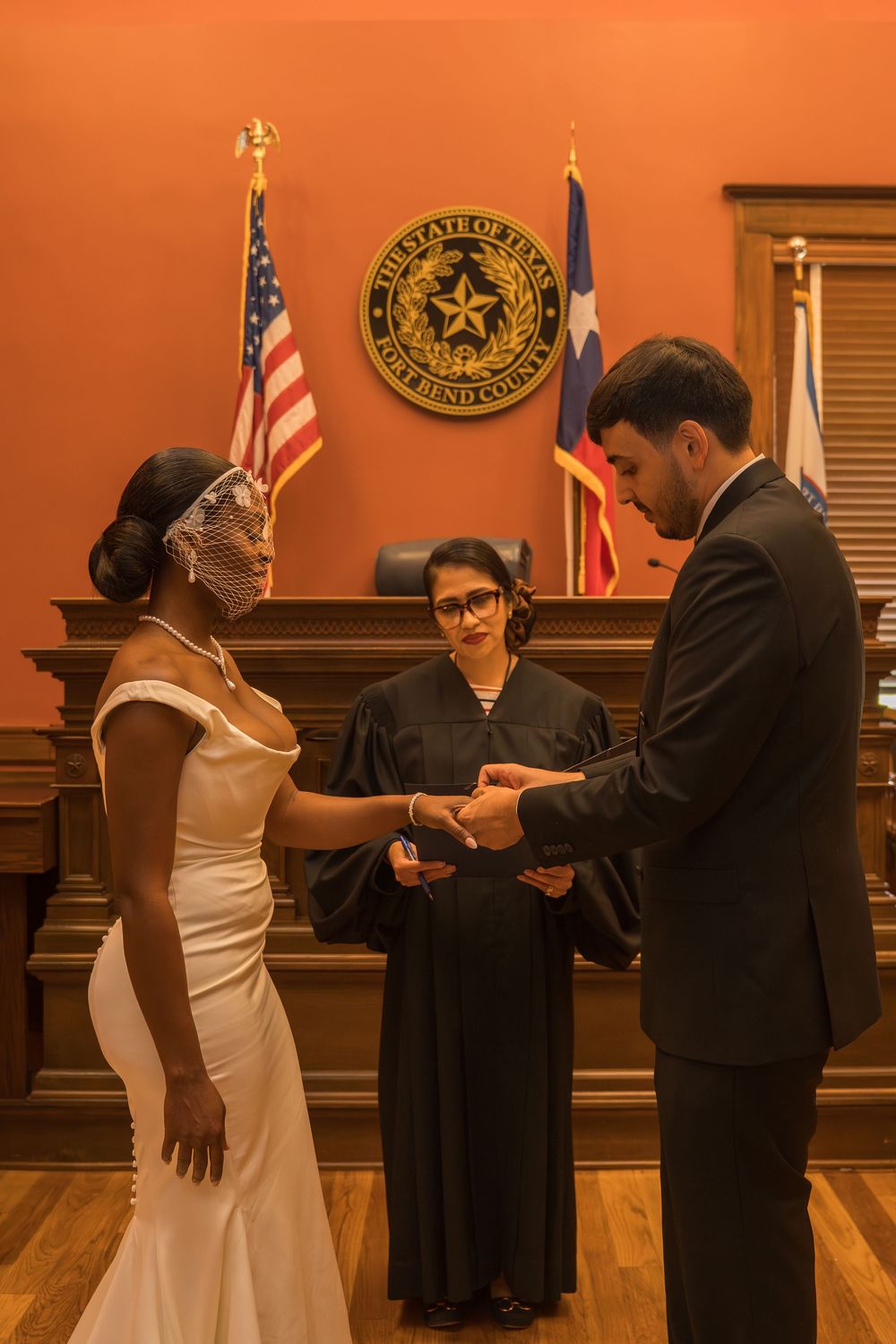 Couple exchanging rings at a Fort Bend County Texas courthouse wedding ceremony officiated by a judge.