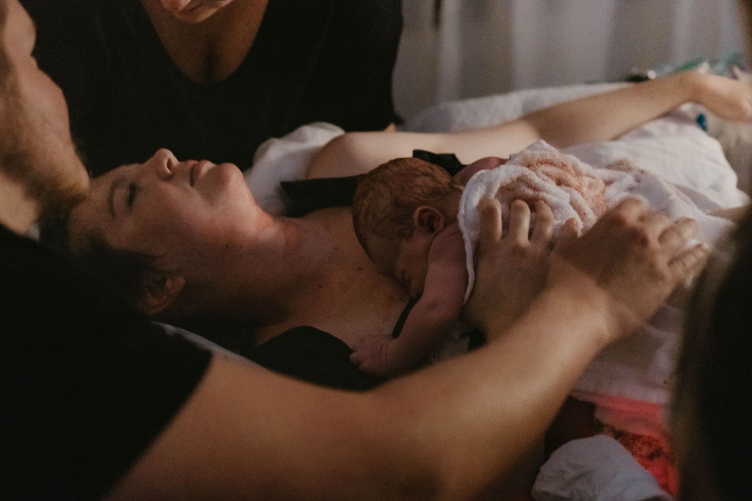 home birth lady just gave birth and is holding baby in her bed