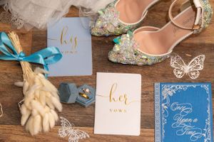 Wedding accessories including blue stationery, decorated shoes and delicate butterfly details.