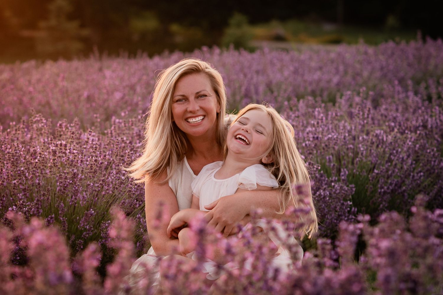 Mother and daughter laughing together in a lavender field at Gray Silo Lavender Farm in Scugog, Ontario.