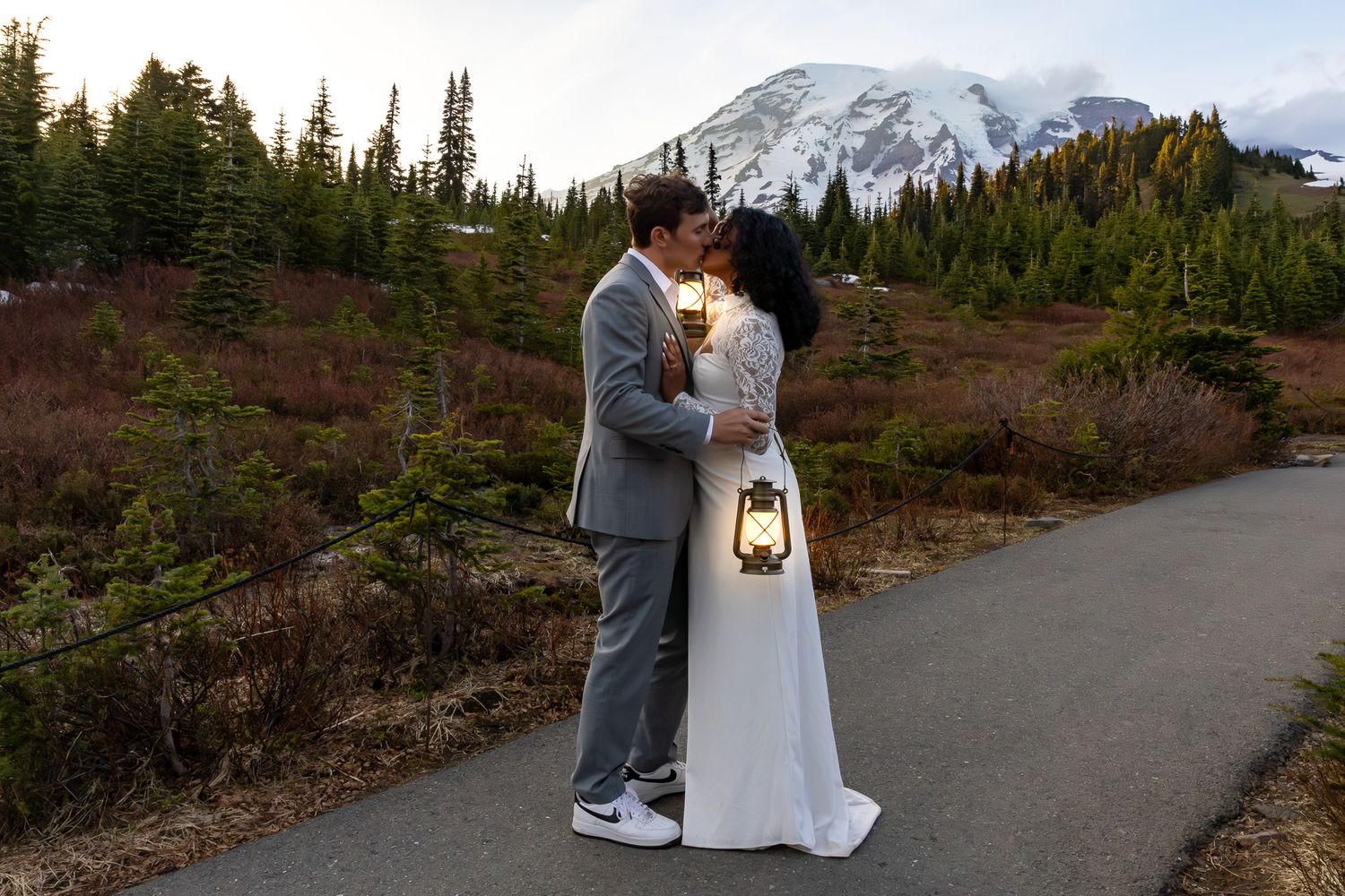 Couple kissing at dusk holding a lantern with Mt. Rainier glowing in the background. PNW Elopement Photographer.