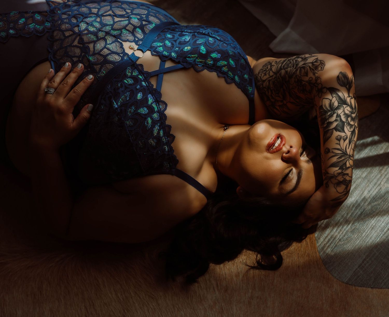 Plus-size boudoir posing in dramatic moody lighting for a boudoir photo by Wisconsin boudoir photographer.