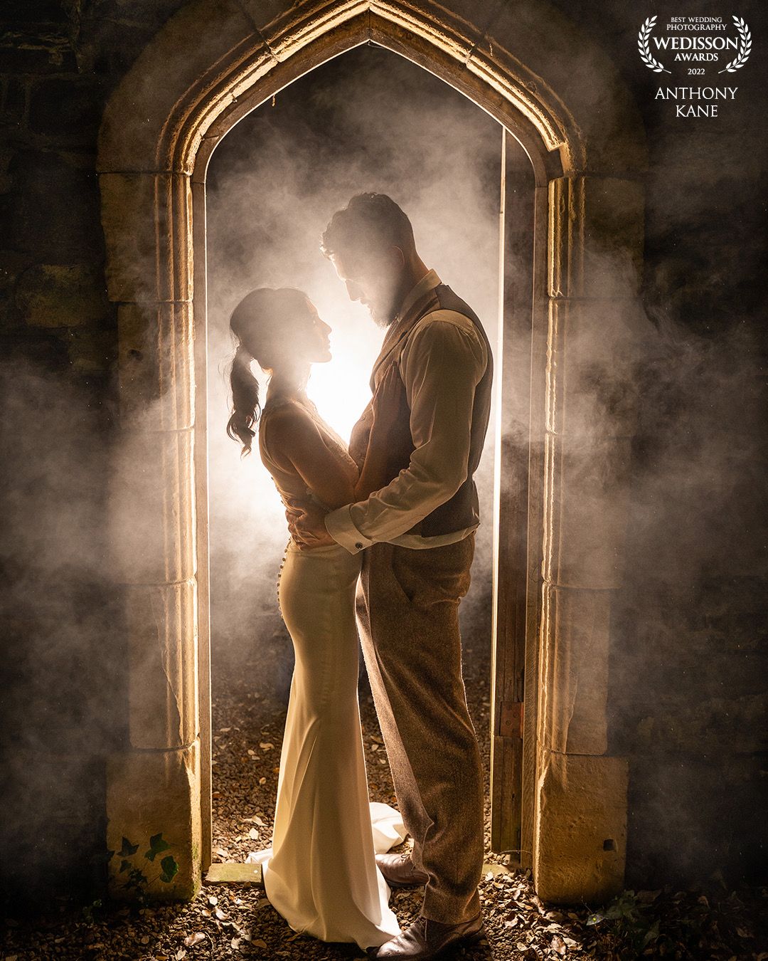 Dramatic backlit silhouettes of couple in gothic archway with atmospheric smoke effects in this award wining photo in Dunshaughlin Castle