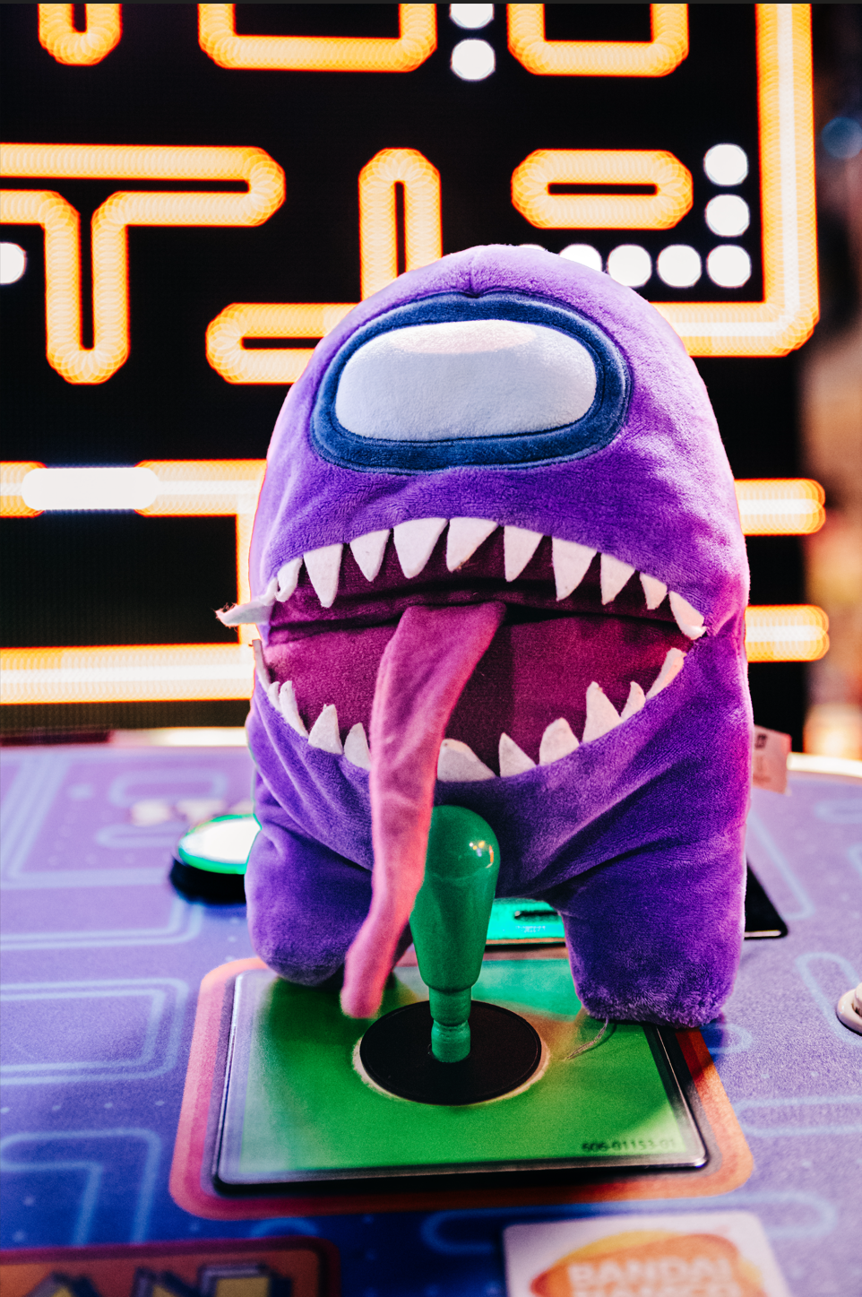 Purple Among Us plush toy sitting on an arcade game during a colorful Fun Depot birthday photoshoot in Lake Worth Beach.