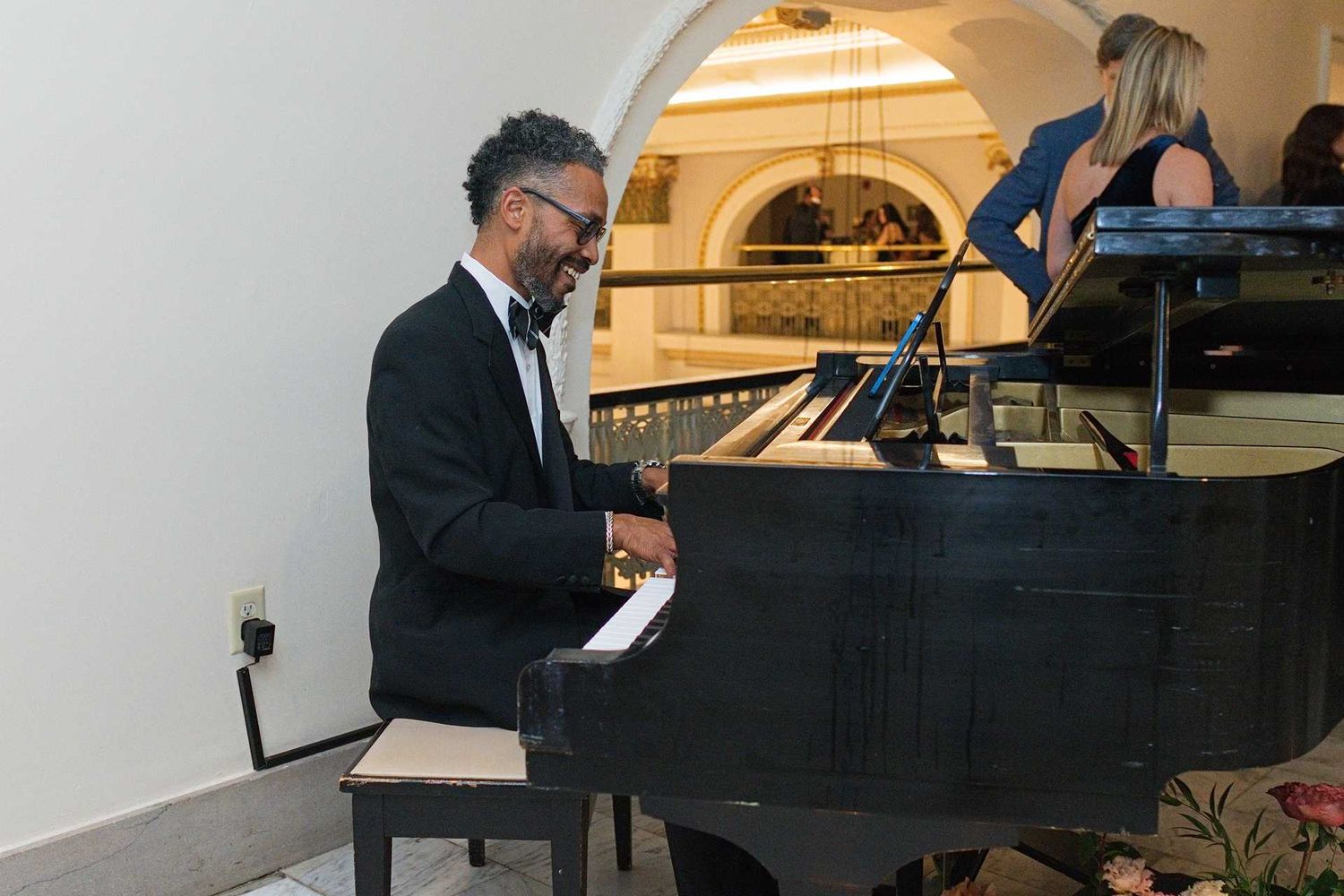 Man in tuxedo playing black grand piano at elegant indoor The Westin Great Southern Columbus Wedding Venue