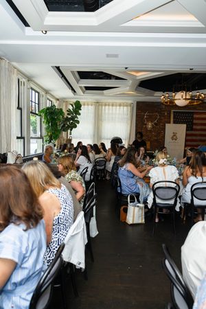 Elegant restaurant dining room filled with women seated at tables during a private luncheon event.