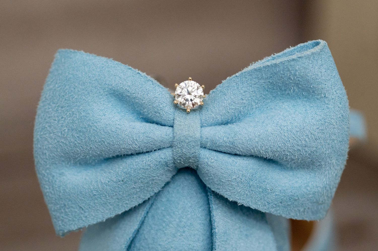 Light blue suede bow tie with a sparkling diamond center jewel, perfect for formal occasions.