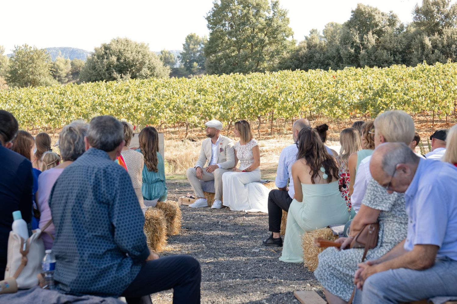 Les invités réunis en plein air face aux mariés, avec les vignes de Pourrières en arrière-plan.