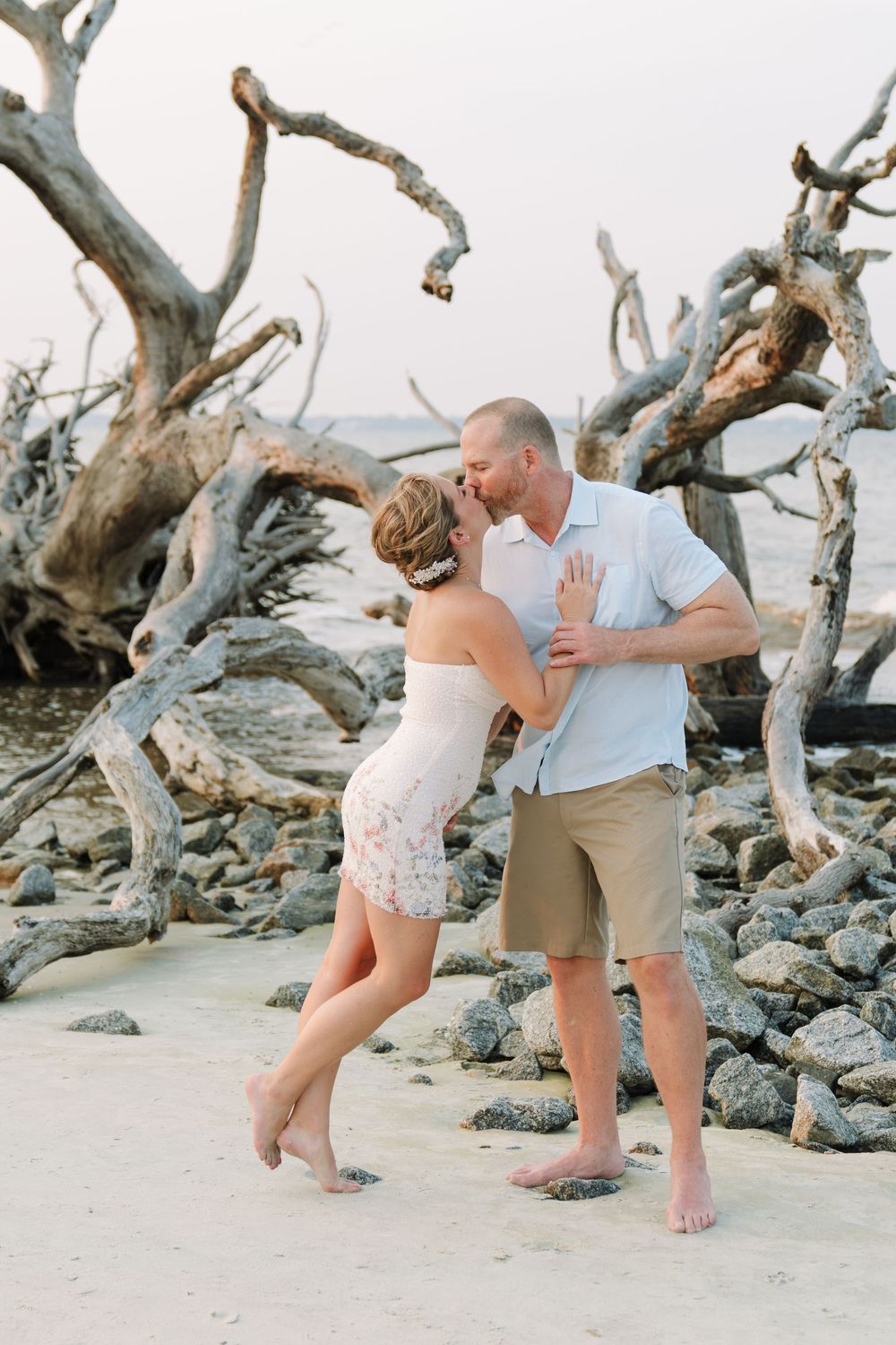 Rachel and Bo lean into each other for a scenic kiss together by the water for their coastal Georgia engagement portraits