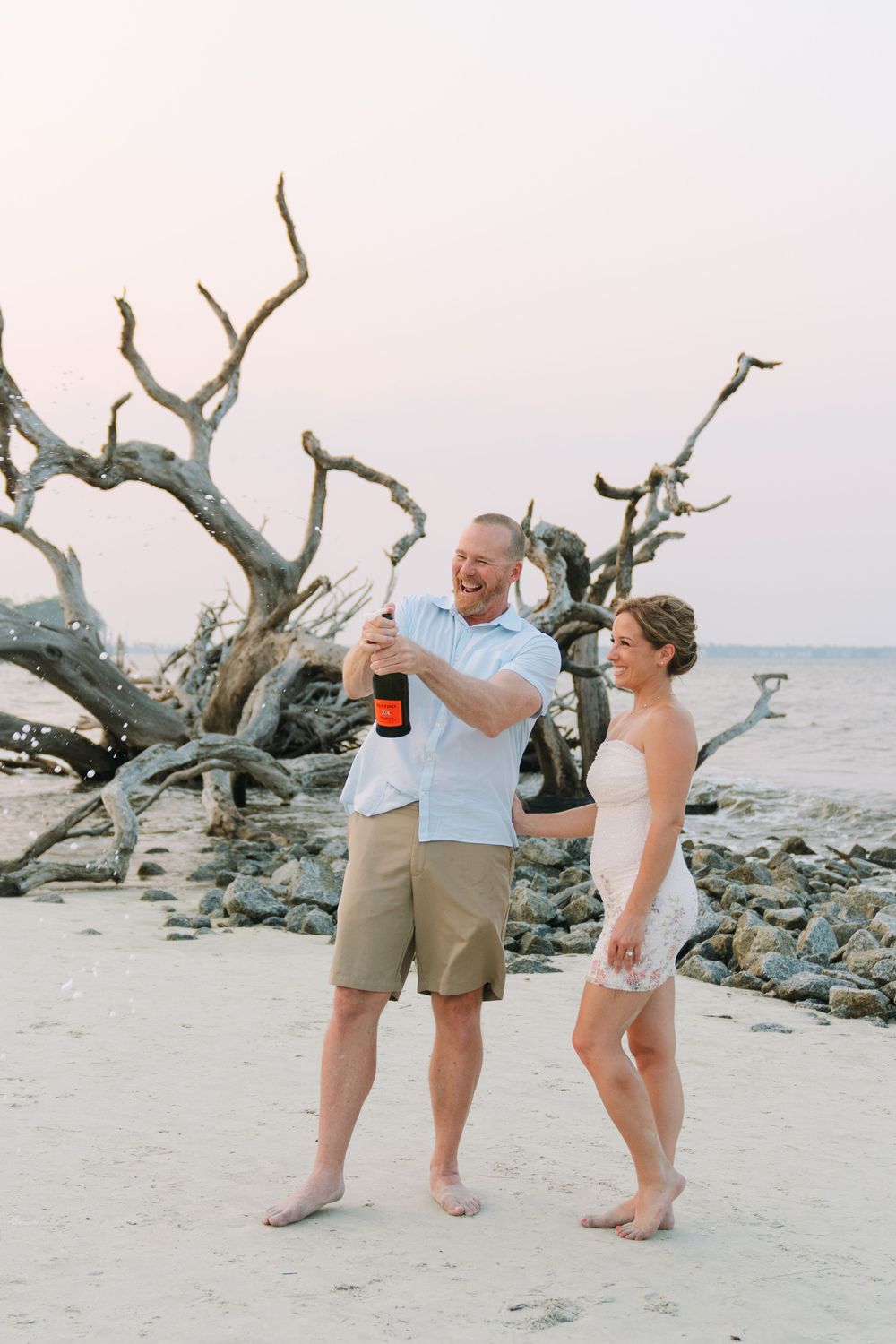 Rachel and Bo share a champagne pop to toast their upcoming wedding and engagement session portraits taken by Lindy Rebro