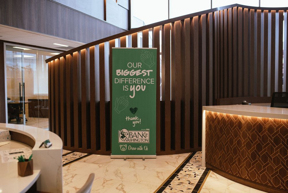 Modern hotel lobby featuring a green banner reading Our Biggest Difference Is You with elegant wood panel decor.