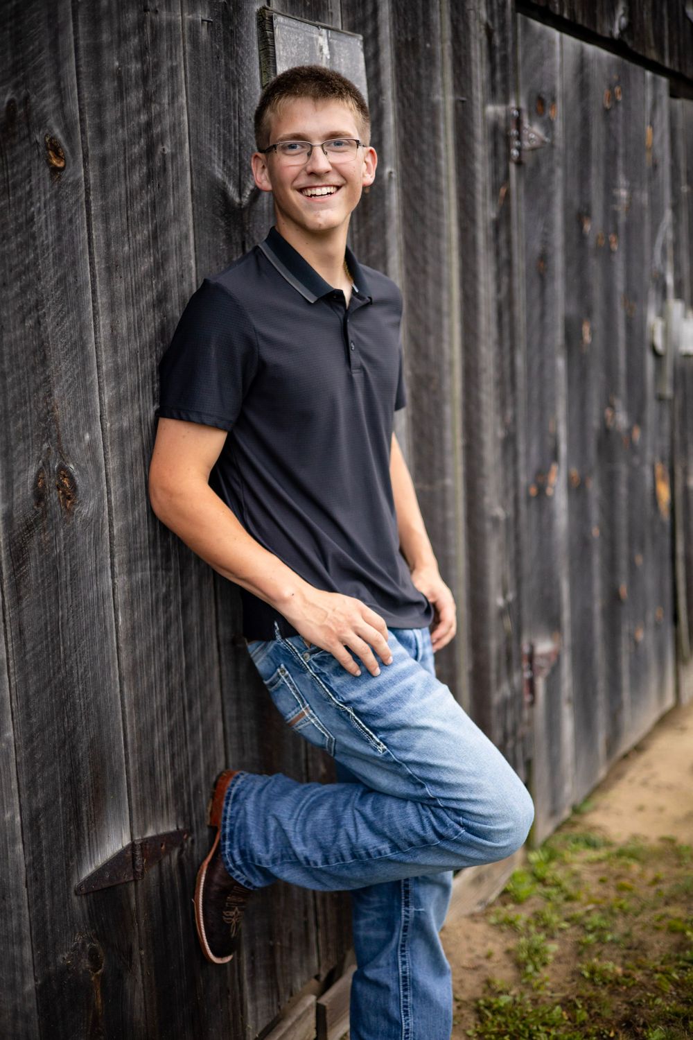 High school senior posing for photos next to a barn in Western Massachusetts