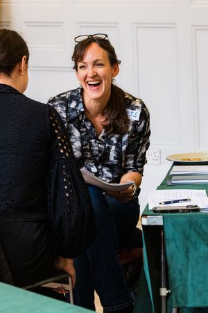 Woman laughing joyfully during a one-on-one business coaching or training session.