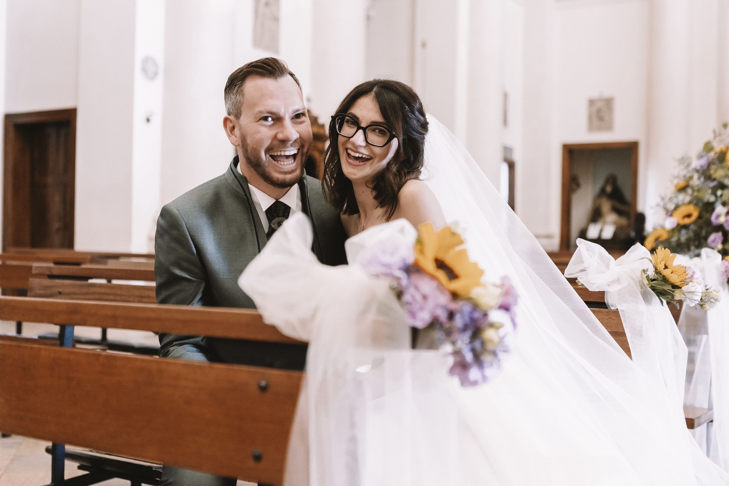 Sposi affacciati dall’auto durante un momento spontaneo del matrimonio