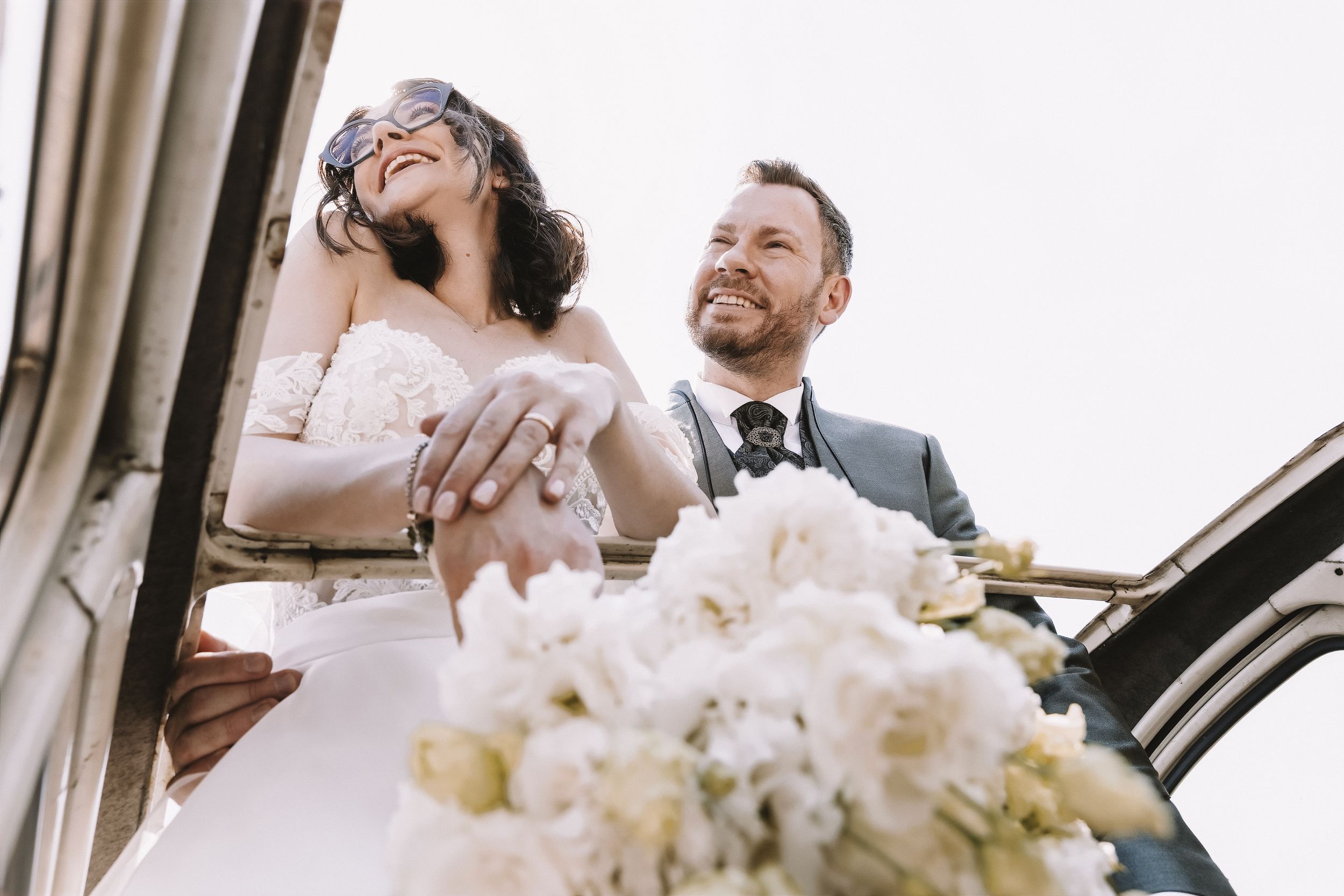 Sposi affacciati dall’auto durante un momento spontaneo del matrimonio