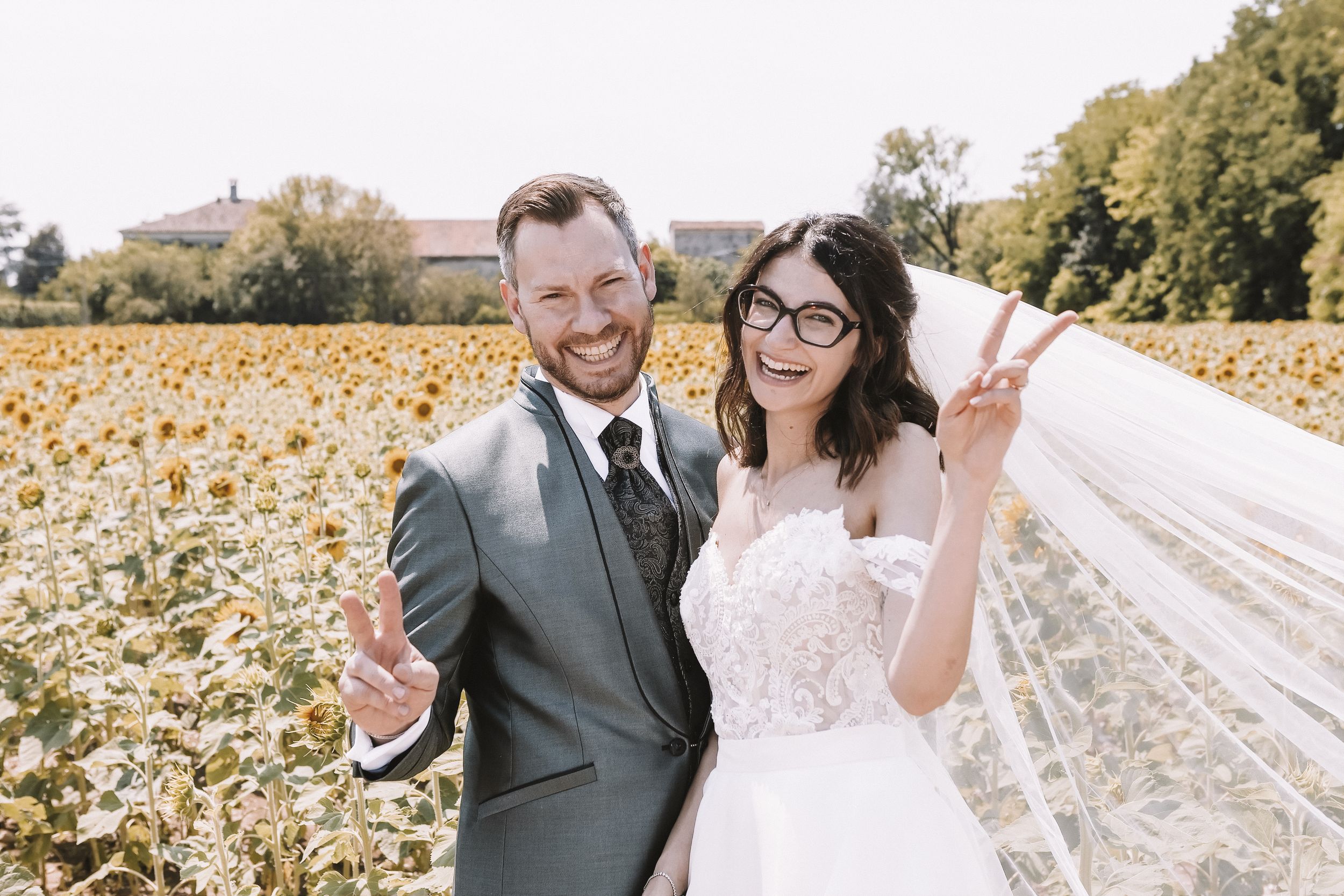 Sposi sorridenti in un campo di girasoli