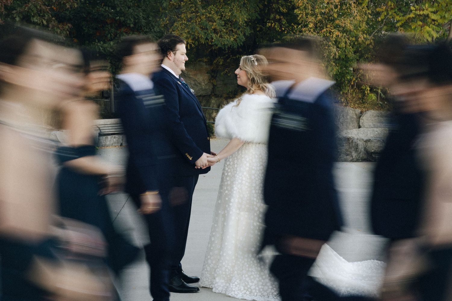 Motion blur photo of a couple in wedding attire surrounded by moving guests during an outdoor ceremony burlington ontario
