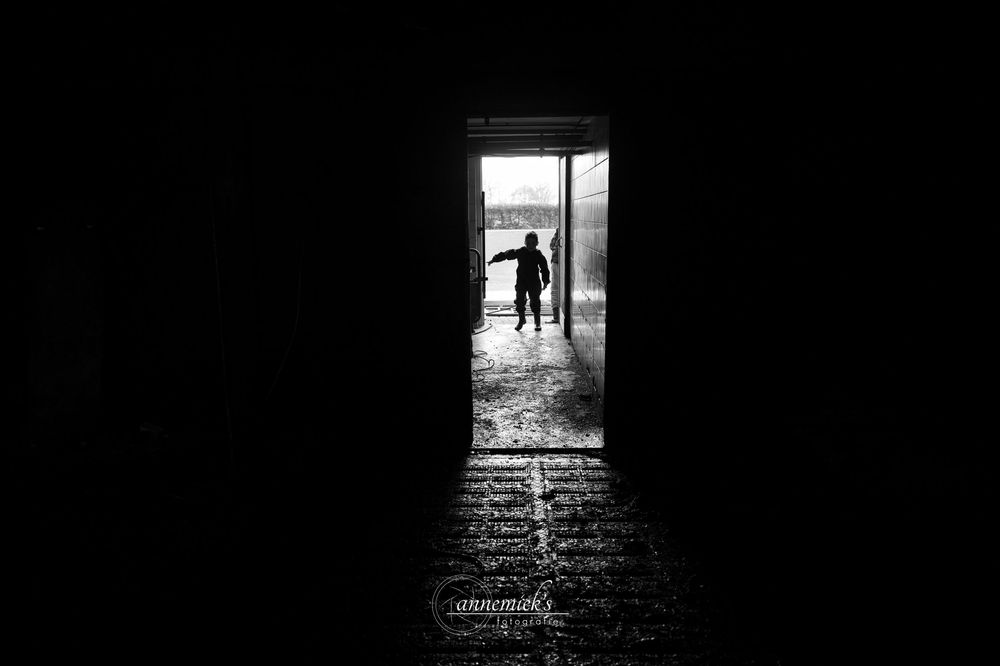 Silhouetted figures framed in a doorway creating a dramatic black and white composition.