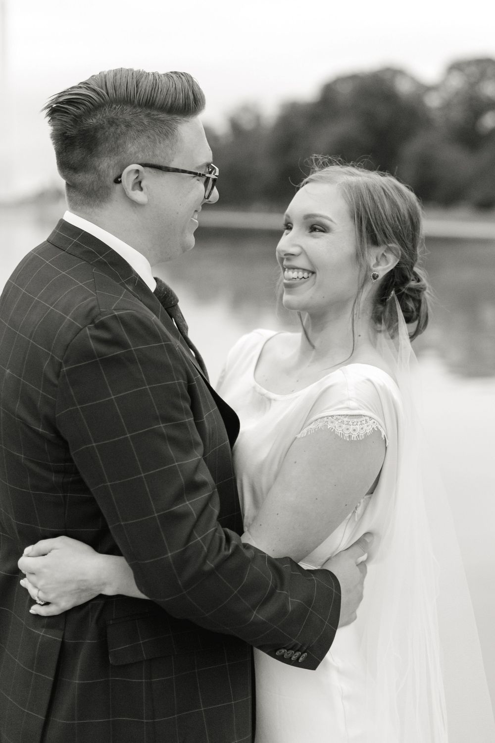 Black and white photo of smiling bride and groom embracing at their Washington DC wedding.