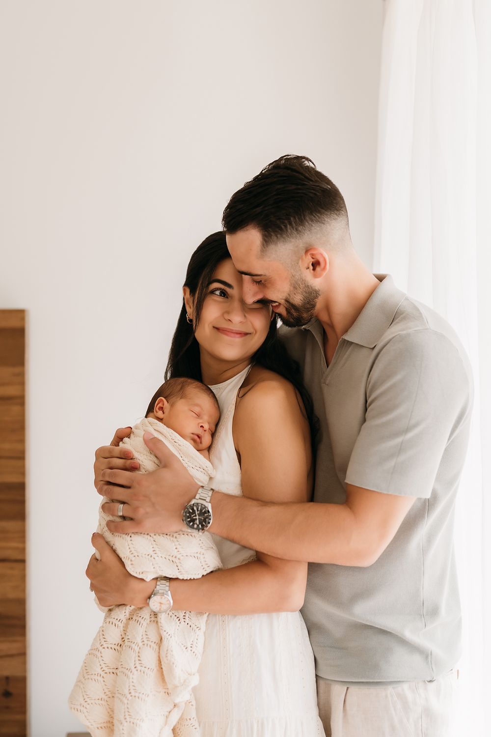 Cuddly moments with a newborn and parents in Sydney home