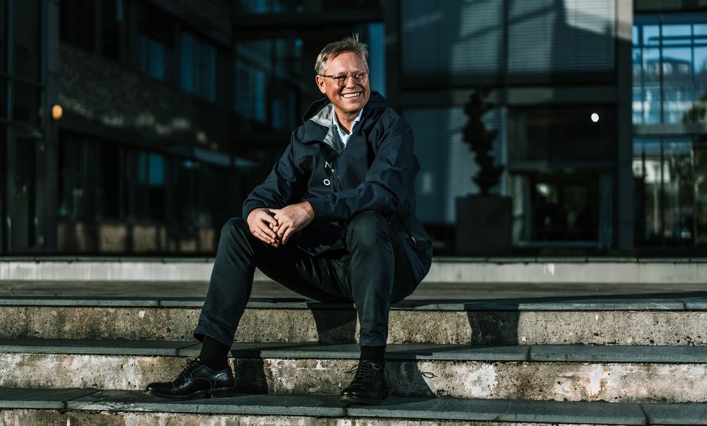 Business executive seated outdoors at modern office building.