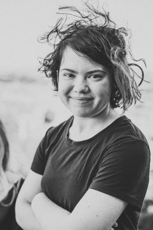 A casual portrait shows windswept hair against an overcast background.