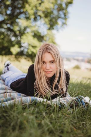 A relaxed outdoor portrait in the grass with soft natural lighting.