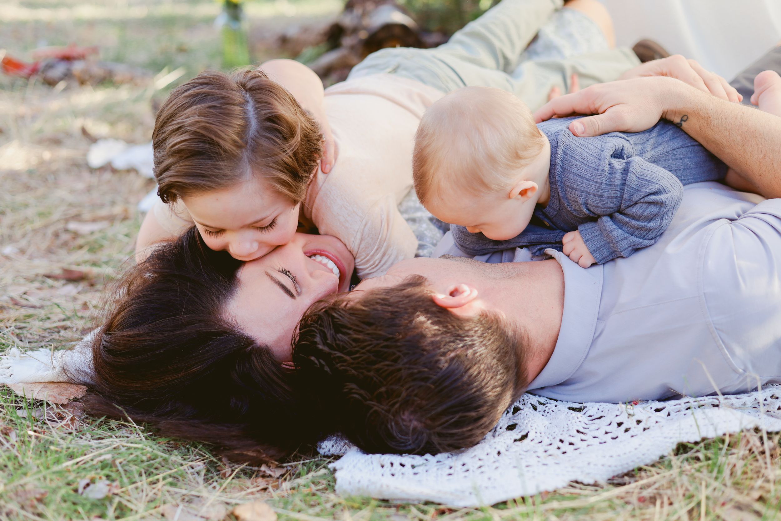 Couple lying together on blanket during romantic outdoor photoshoot.