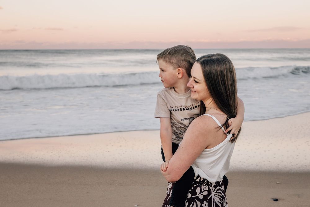 Sunset beach photography session with warm tones and ocean waves in background.