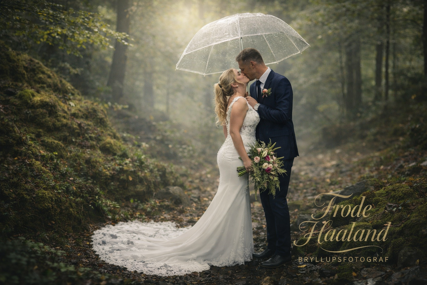 Black and white wedding photo of couple sharing a kiss by the water with bride's veil blowing in wind.