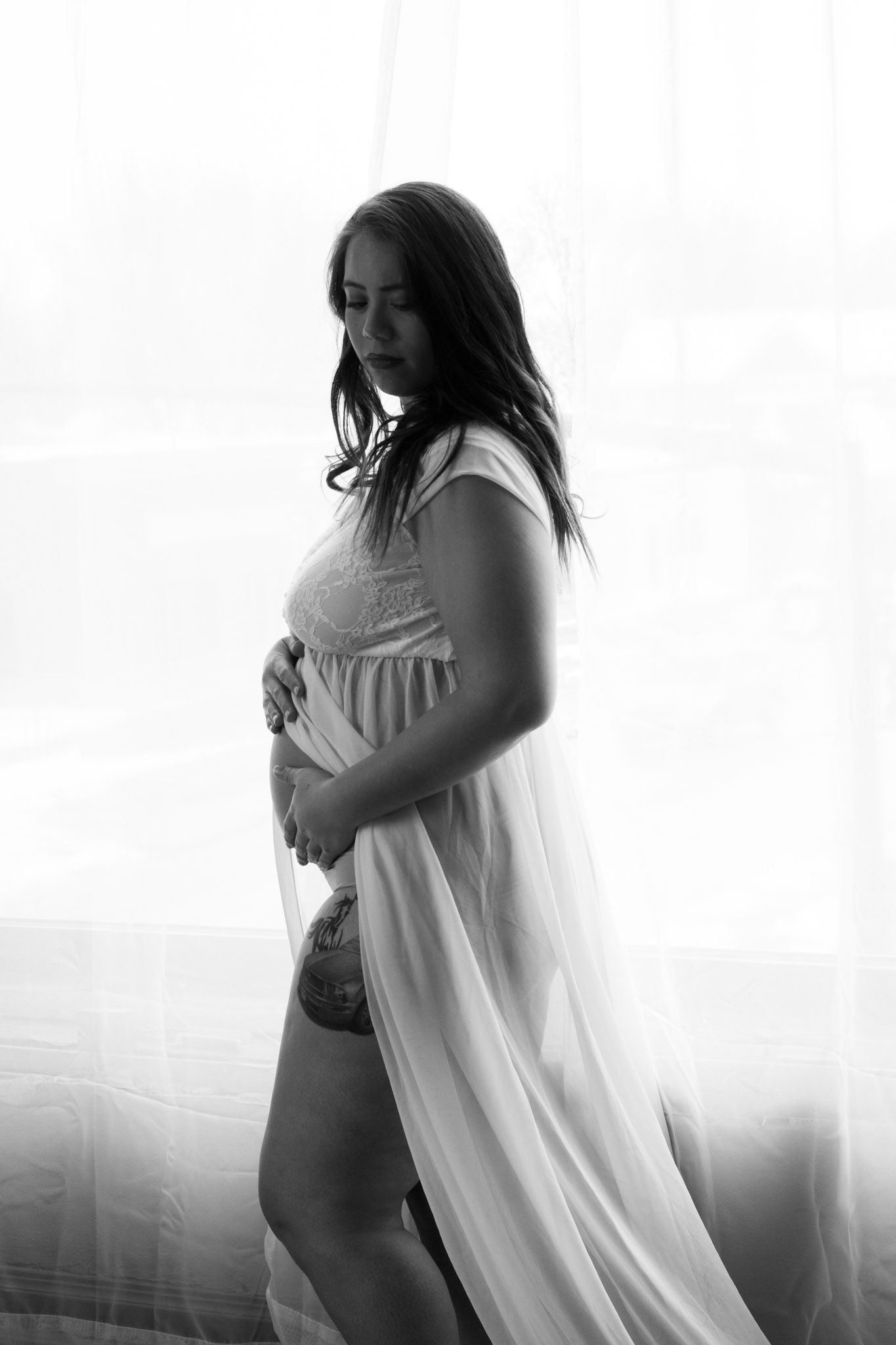 Black and white portrait showing silhouette in flowing white dress.
