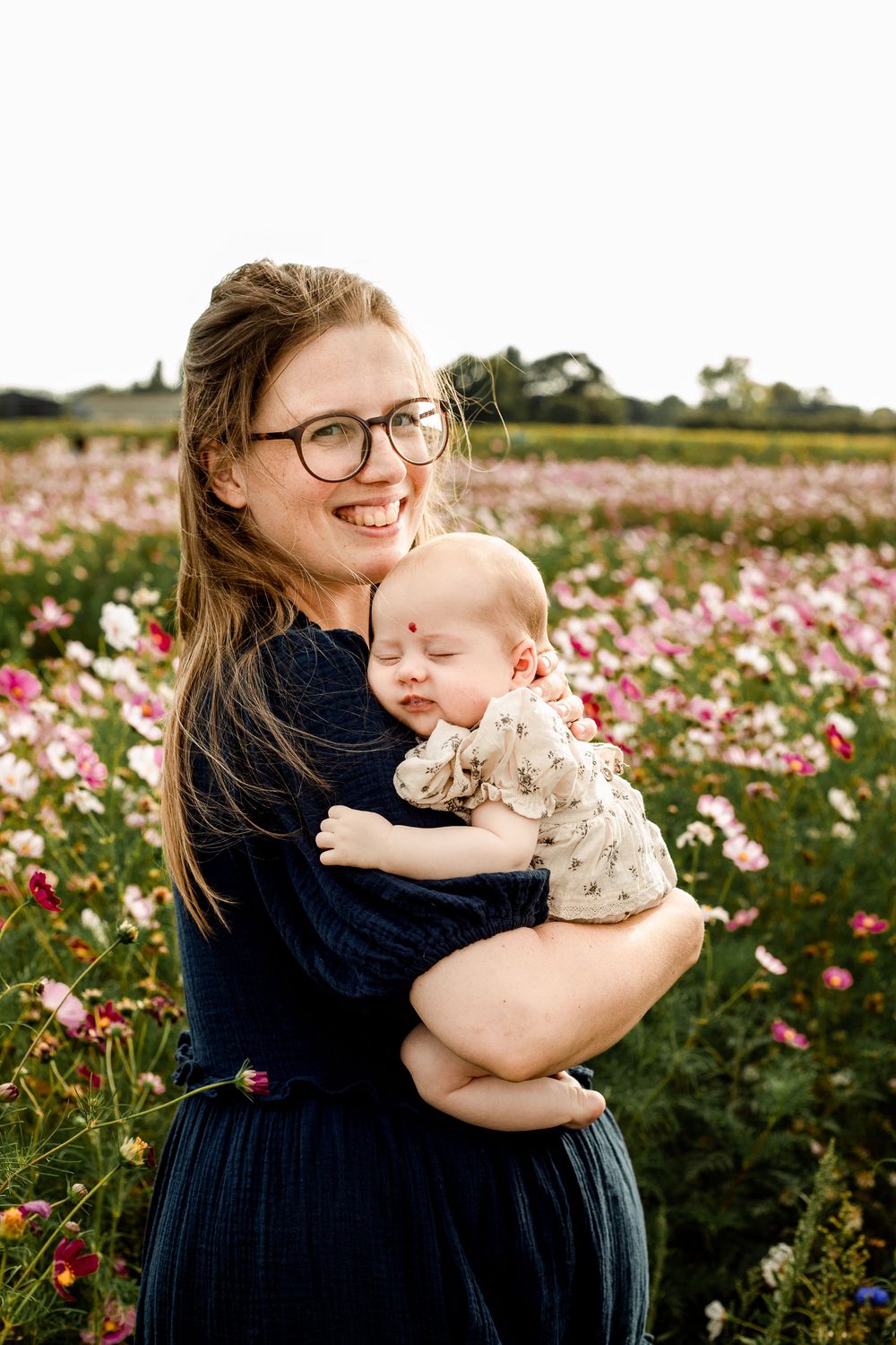 At Sam's Sunflowers on Hayling Island, Hampshire, a Mum and her Daughter stands hugging amongst the wildflowers.
