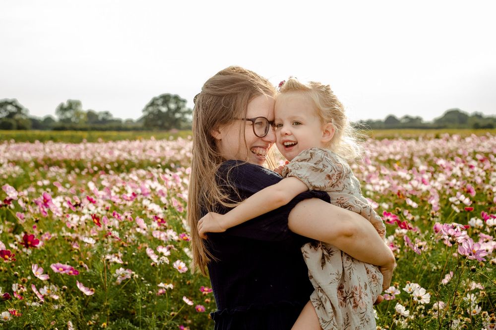 At Sam's Sunflowers on Hayling Island, Hampshire, a Mum and her Daughter stands hugging amongst the wildflowers.