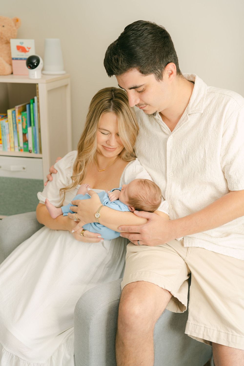 A series of five intimate photographs showing tender moments between parents and their newborn baby in a light-filled bedroom.