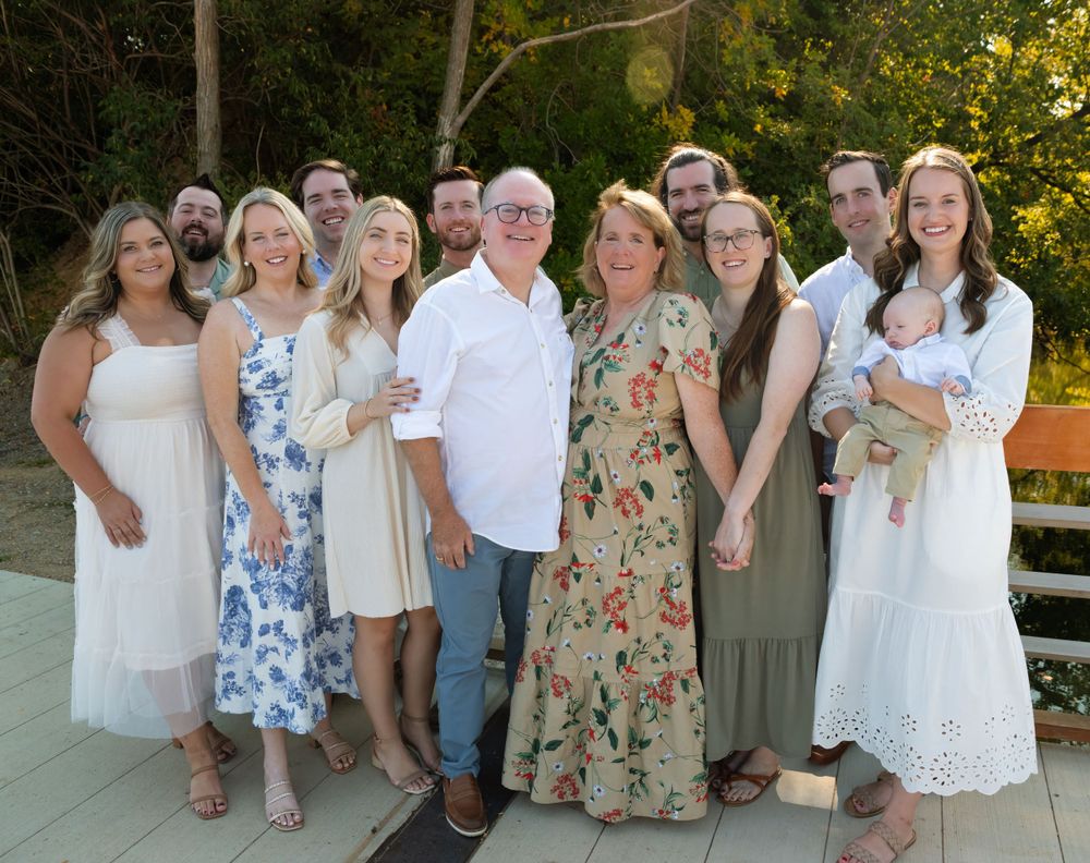 Extended family group photo in coordinated white and floral summer outfits.