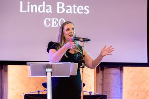Summerhouse Houston CEO giving opening remarks on stage at a fundraising gala inside **The Bell Tower on 34th ballroom in Houston, TX.