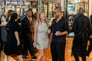 Candid shot of smiling corporate guests socializing at a luxury charity gala dinner in Houston, TX