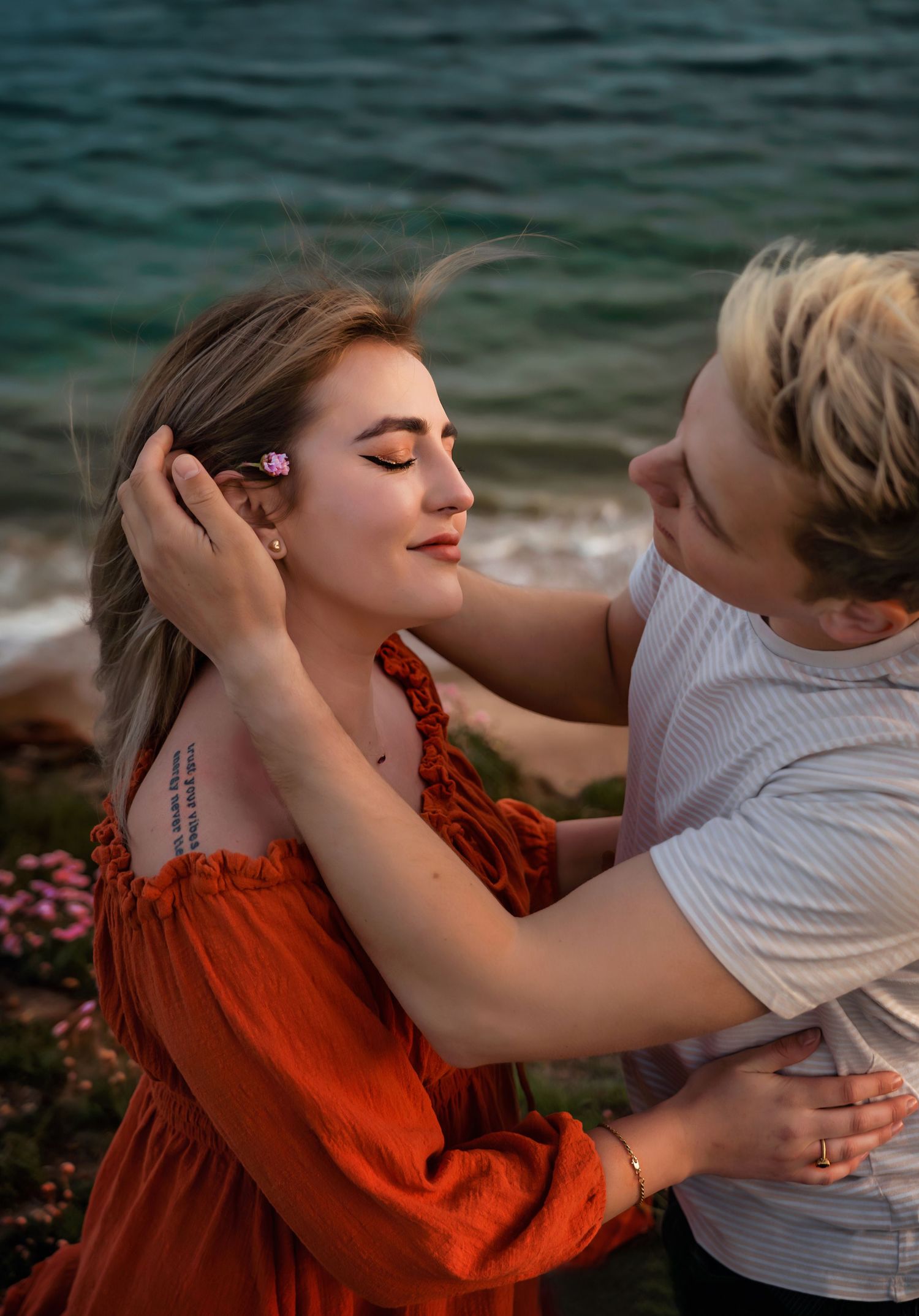 A gentle touch between a man and a woman at a photo session at the beach, Hengistbury Head, Dorset.