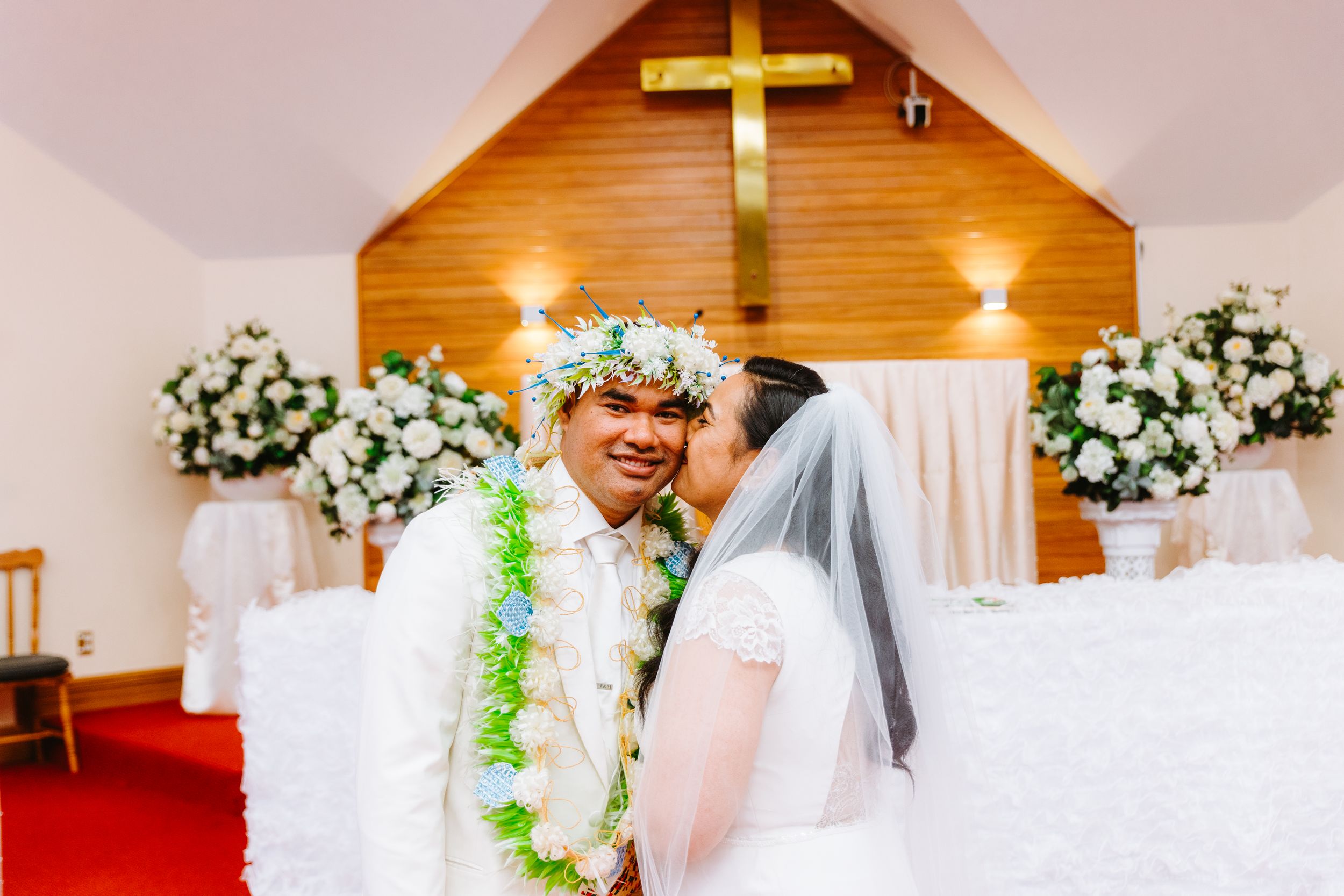 Joyful wedding ceremony in a Wellington church with white florals - timeless, emotional wedding photography.
