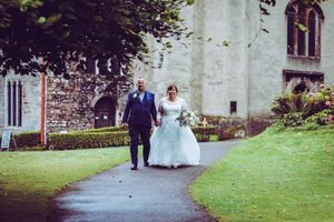 Bride and groom walking away from Cockington church
