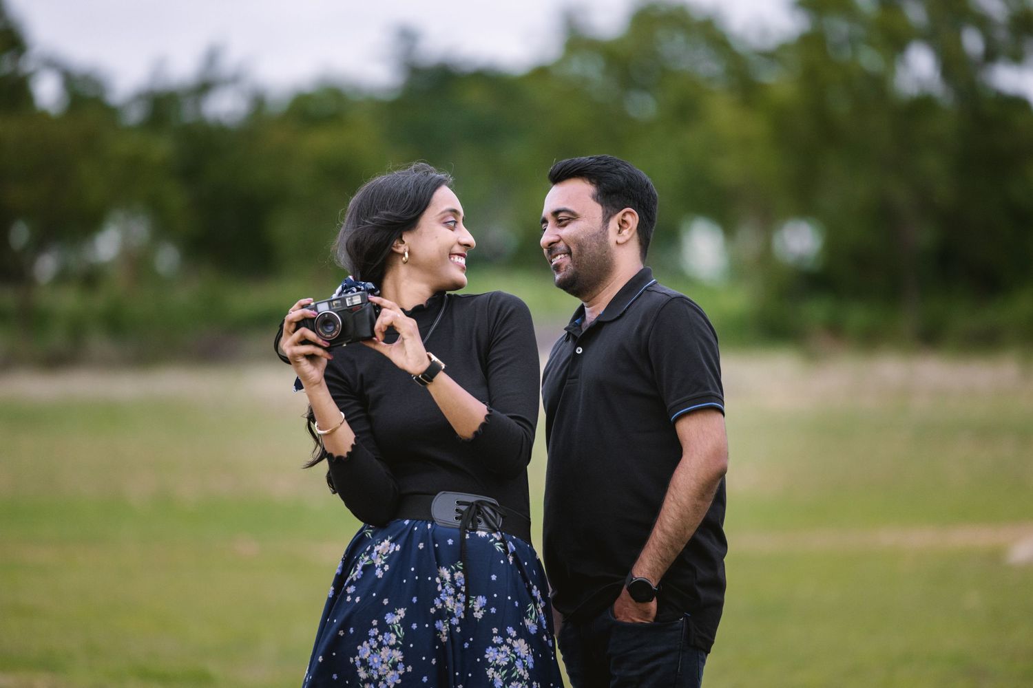 Couple sharing a joyful moment outdoors in casual attire.