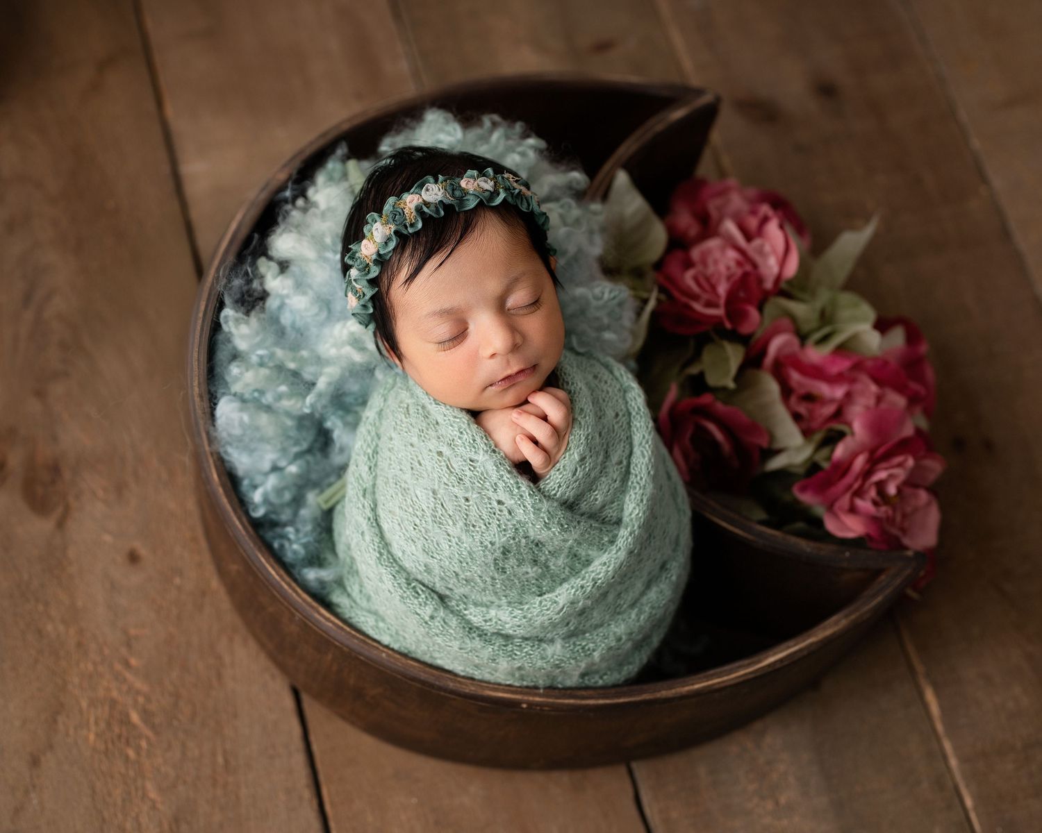 Mint green themed newborn photography with baby sleeping in vintage bowl with pink floral accents.