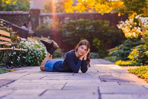 senior girl lays on stone walkway