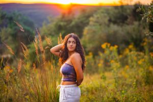 in a field of tall flowers this senior girl poses and is camera ready