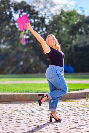 capturing a candid celebratory pose as she throws her cap and gown